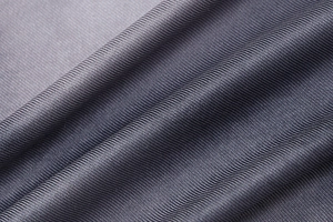 Macro shot of dark gray fine knit fabric texture with soft shadows and sharp fibers