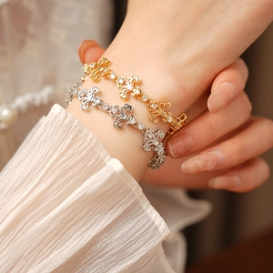 Gros plan de bracelets fleurs d'iris or et argent au poignet de style vintage français