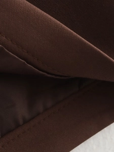 Macro shot of brown fabric texture and precise stitching on a vintage skirt suit