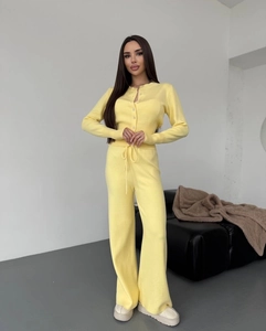 Detail of soft knit texture on vibrant yellow buttoned cardigan and wide-leg pants set