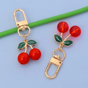 Cute cherry pendant keychain for AirPods case and bags featuring vibrant red fruit and gold hardware
