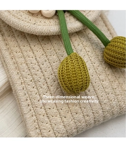Detailed macro shot of 3D textured cream knit bag with green cords and yellow accents