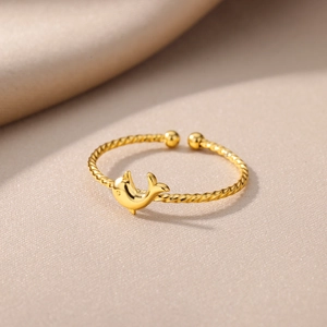 Close-up of golden dolphin ring featuring a twist rope band and polished finish