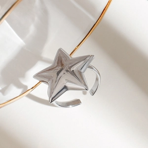 Close-up of polished silver titanium steel ring with a 3D star and adjustable band