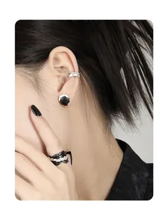 Detail of S925 sterling silver ear cuff and ring with irregular dark lava texture