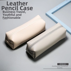 Detail of minimalist leather makeup brush bags with smooth metal zippers in neutral colors