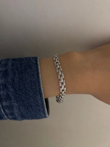 Close-up of minimalist silver stainless steel chain bracelet with zircon on wrist