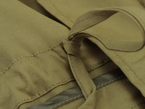 Détails de la parka en sergé olive avec coutures renforcées et cordon de serrage robuste