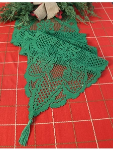 Detail of green lace table runner with fringes and hollow pattern for Christmas decor