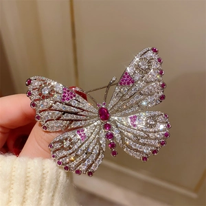 Elegant hollow butterfly brooch with ruby red gemstone and sparkling rhinestones