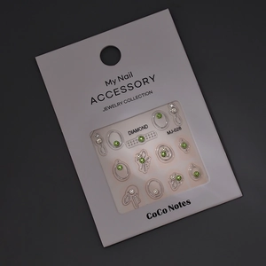 Macro shot of green and white K9 rhinestones in silver settings on a white MJ-028 card