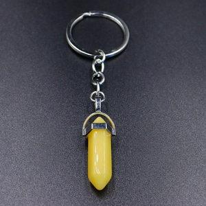 Detail view of yellow hexagonal crystal pendant attached to a silver keychain ring