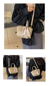 Detail showing khaki lychee texture leather bag with elegant printed silk scarf handle