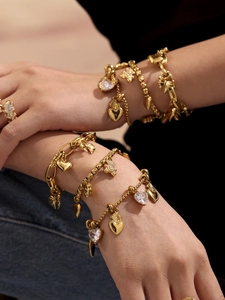Detail of 18k gold plated stainless steel bracelets with heart and crystal charms