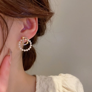 Gros plan détaillé de boucles d'oreilles lettre D avec strass brillants et perles blanches