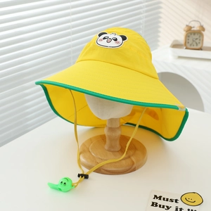 Dettaglio cappello sole giallo per bambini con patch panda e fischietto verde