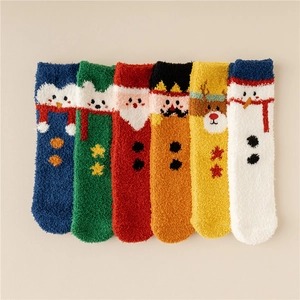 Flat lay of six colorful coral fleece Christmas socks with festive cartoon patterns