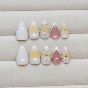 French gradient press-on nails with 3D floral accents in peach and cream colors