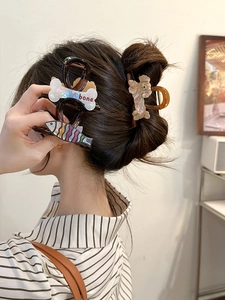 Detail view of acetate dog and bone hair claws worn in hair for a stylish look