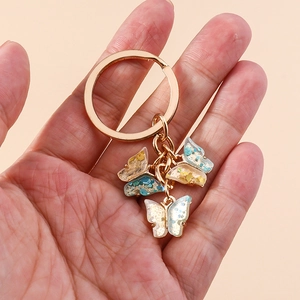 Detailed close-up of colorful butterfly keychains with rainbow sequins and gold hardware