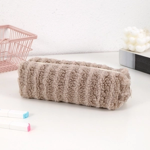 Detail of plush khaki pencil case with striped texture and durable zipper closure