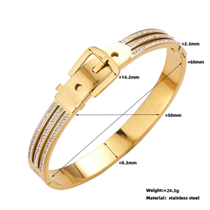 Detail of golden buckle bracelet with three rows of white cubic zirconia and engraved logo