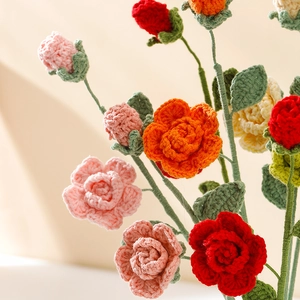 Hand-crocheted colorful rose bouquet in red, pink, and orange yarn for home decoration