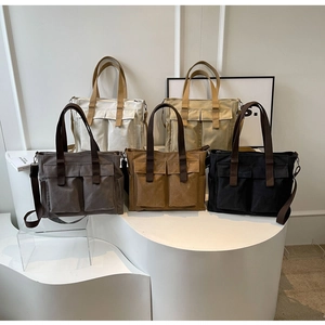Detailed arrangement of five canvas tote bags in white beige grey brown and black colors