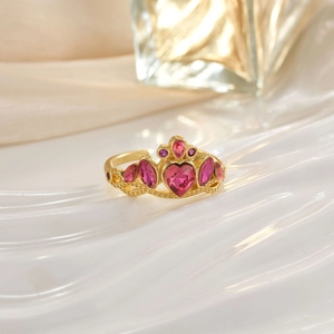 Detailed view of a golden crown ring set with pink heart and teardrop-shaped gemstones