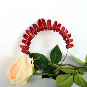 Detail of handmade red crystal headband with gold wire wrap and yellow rose accent