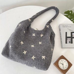 Détail du nœud brodé sur un sac cabas gris foncé avec doublure à carreaux vichy