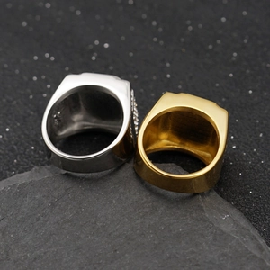 Polished gold and silver gemstone rings displayed on a dark natural stone background