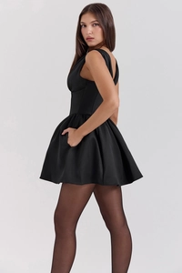 Close-up of black sleeveless satin mini dress with tight waist and flare skirt detail
