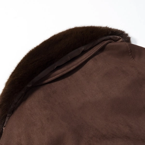 Détail du col en fausse fourrure et du daim marron sur la veste courte chic