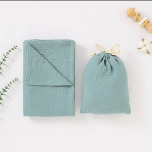 Dual-layer cotton muslin baby swaddle blanket set with matching drawstring bag in blue