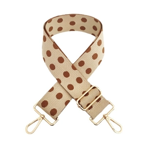 Close-up of adjustable wide shoulder strap with brown polka dots and gold metal hooks