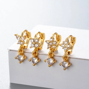 Gold earrings with micro-set zircon butterfly, star and clover charms on white stand