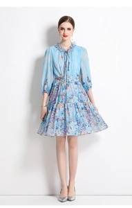 Close-up of ruffled neckline and floral print details on a light blue chiffon dress