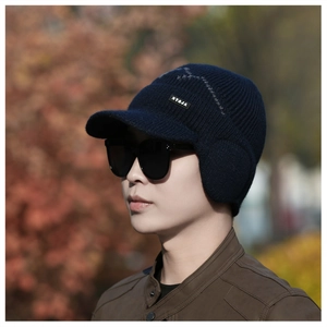 Detail of the navy blue knit earflap cap with NY&JA badge and warm thick texture