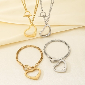 Détail de colliers et bracelets cœur or et argent avec fermoirs à bascule sur tissu