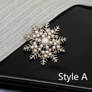 Detailed view of Style A snowflake brooch with golden plating and pearl embellishments