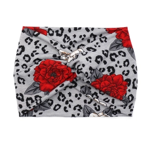 Detail of bohemian wide headband with gray leopard print and vibrant red floral pattern