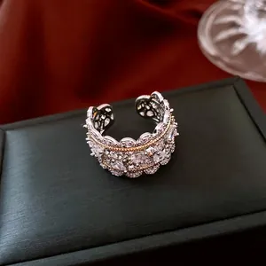 Elegant baroque hollow open ring with clear zircons and golden beaded edge on black jewelry box