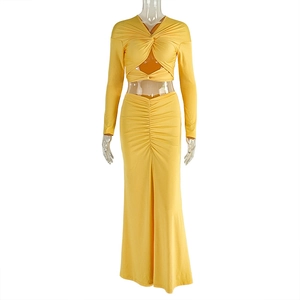 Detail of yellow two-piece set featuring a twisted crop top and ruched maxi skirt
