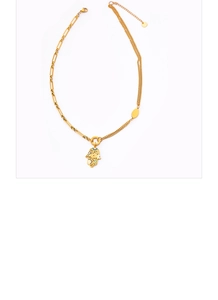 Detailed shot of gold Hamsa Hand pendant on asymmetric paperclip and multi-strand chain