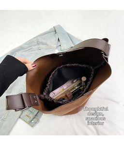 Internal view of brown bucket bag showing spacious storage with a drawstring liner pouch