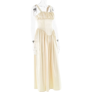 Detail of a beige maxi dress featuring a pleated bust, thin straps, and flowing skirt