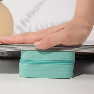 Pressure test showing the compact mint green PU leather jewelry box with zipper