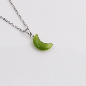 Gros plan du pendentif croissant de lune vert poli avec un collier en chaîne argentée
