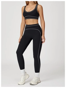 Detail shot of black high-waisted yoga leggings with white contrast stitching details
